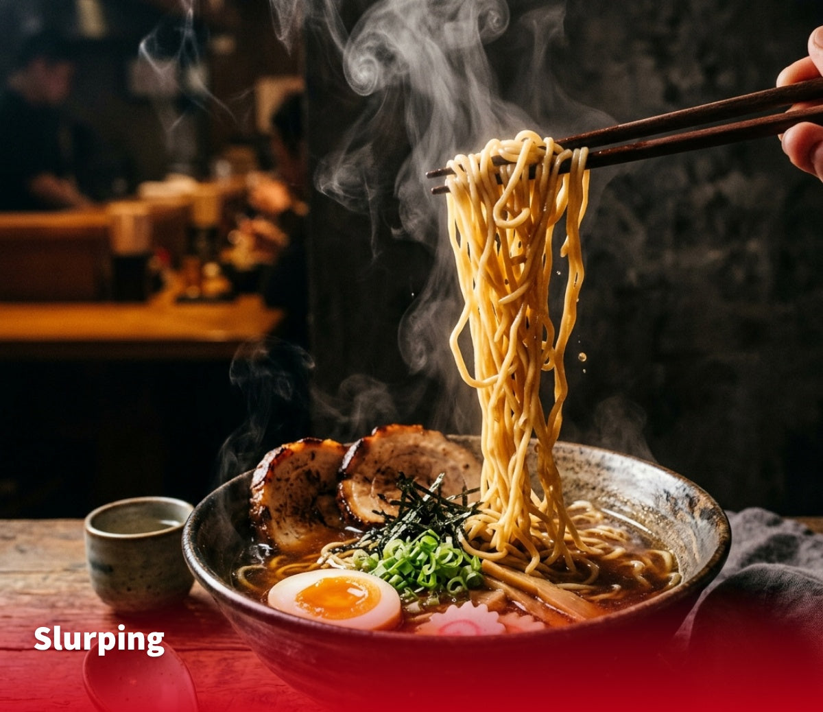 Chopsticks lifting steaming noodles from a bowl of ramen topped with pork, egg and scallions